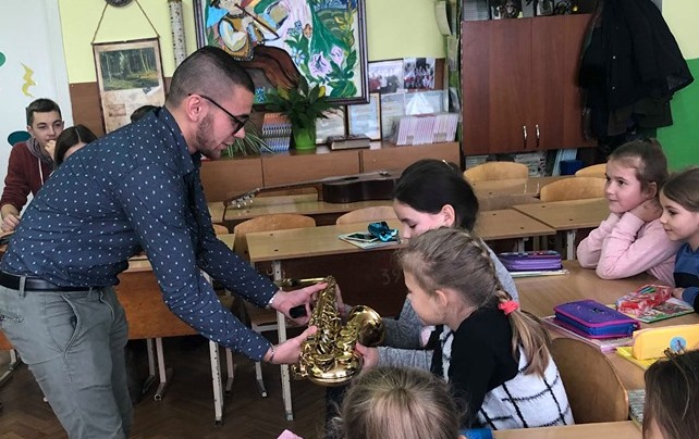 Іван Курій демонструє школярам саксофон